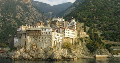 Mount Athos monastery on cliffs above the Aegean Sea — pilgrim transfers to Ouranoupoli with MTG Travel