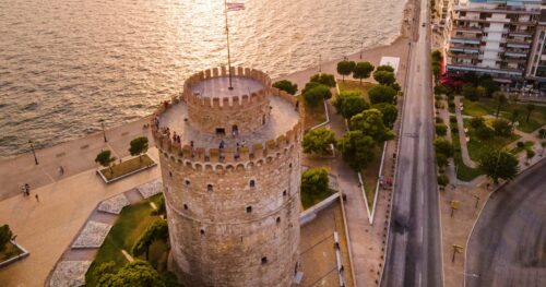 White Tower of Thessaloniki at sunset with calm waterfront promenade — private city transfers from SKG Airport